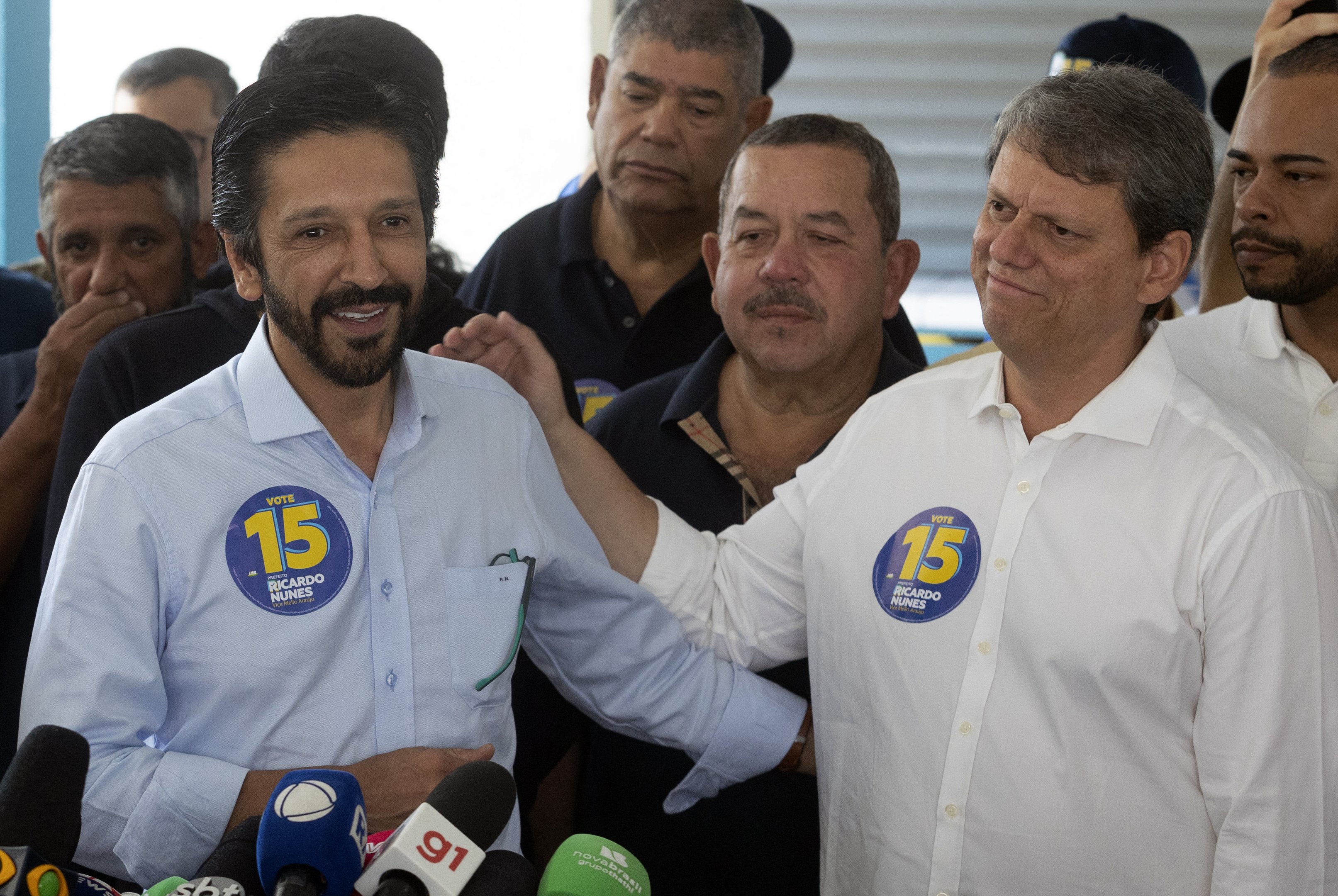 Sao Paulo city mayor and candidate for re-election Ricardo Nunes (L), of the Movimento Democratico Brasileiro (MDB), speaks with the media next to São Paulo Governor Tarcisio de Freitas after casting his his vote during the municipal elections first round, in Sao Paulo, Brazil, on October 6, 2024. Brazilians go to the polls Sunday to elect mayors and councillors in more than 5,500 cities after a vitriolic, sometimes violent campaign two years after presidential elections that polarized Latin America's biggest country. (Photo by Nilton Fukuda / AFP)