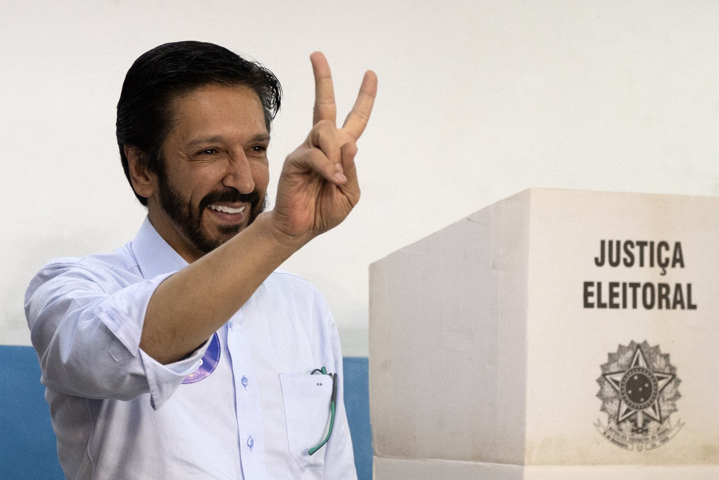 Sao Paulo city mayor and candidate for re-election Ricardo Nunes, of the Movimento Democratico Brasileiro (MDB), flashes the victory sign while casting his vote during the municipal elections first round, in Sao Paulo, Brazil, on October 6, 2024. Brazilians go to the polls Sunday to elect mayors and councillors in more than 5,500 cities after a vitriolic, sometimes violent campaign two years after presidential elections that polarized Latin America's biggest country. (Photo by Nilton Fukuda / AFP)