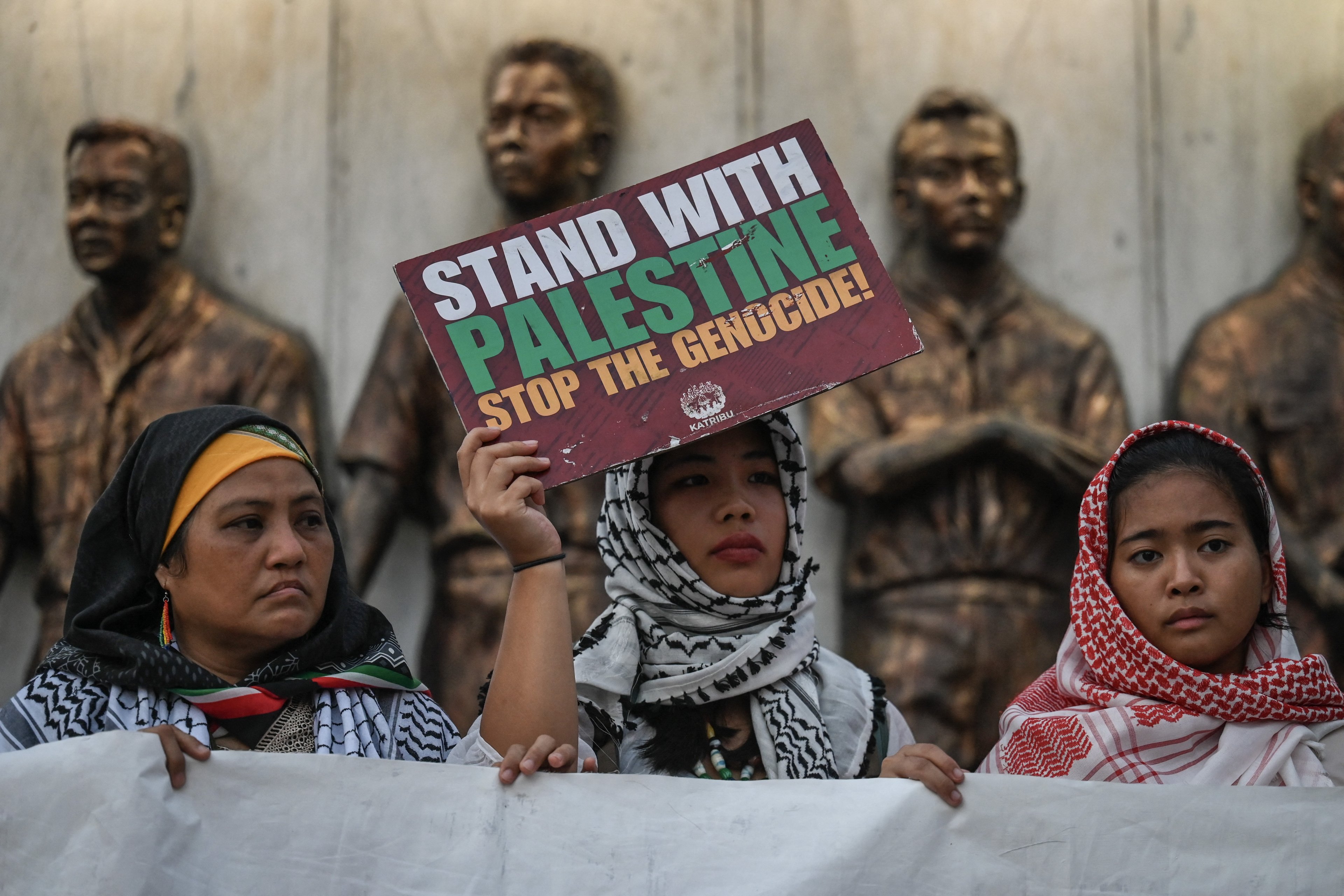 Manifestantes seguram cartazes durante um comício pró-palestino realizado para marcar o primeiro aniversário do conflito Israel-Hamas, em Quezon City, Metro Manila, em 7 de outubro de 2024