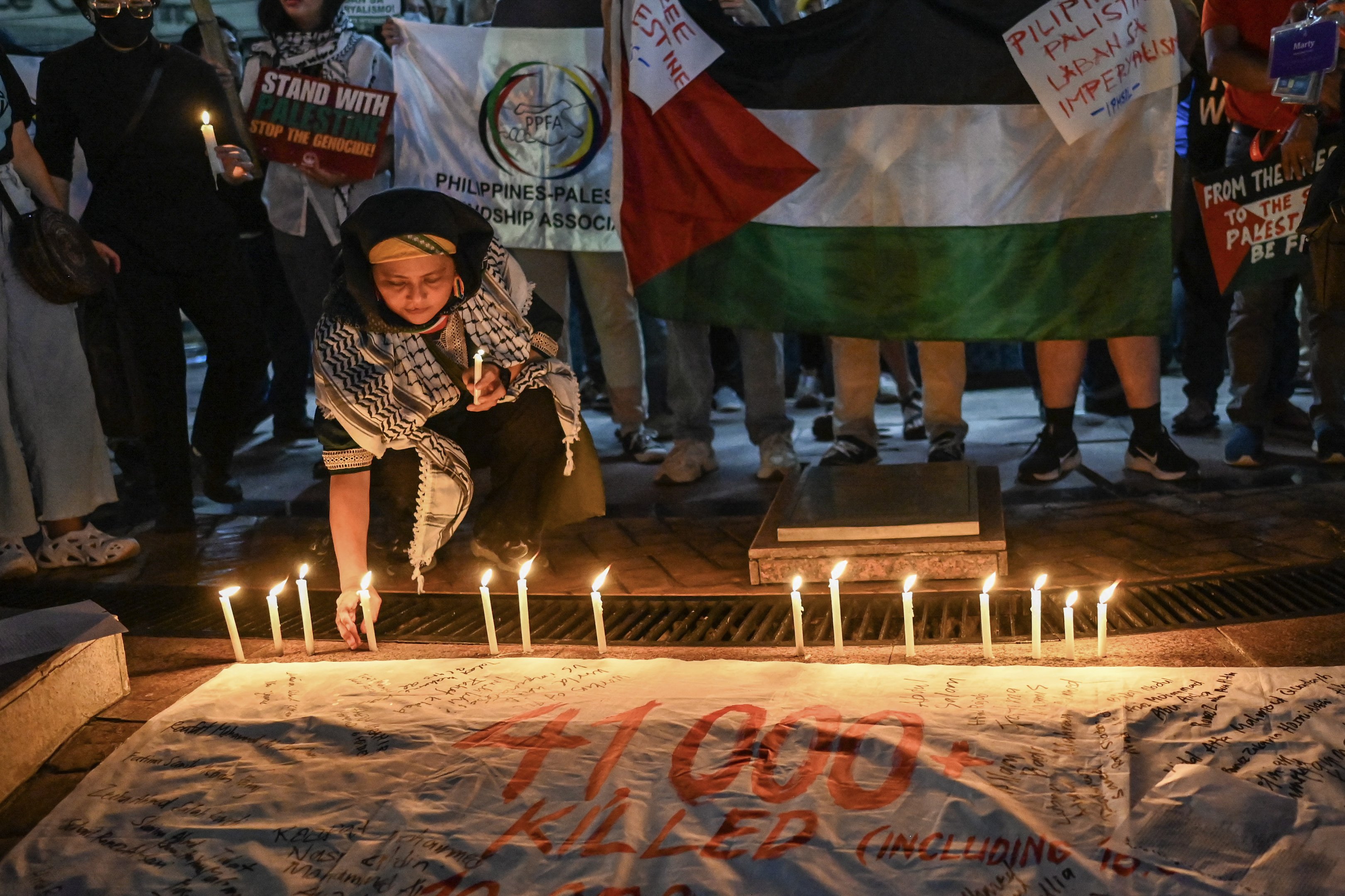 Manifestantes acendem velas durante um comício pró-palestino realizado para marcar o primeiro aniversário do conflito Israel-Hamas, em Quezon City, Metro Manila, em 7 de outubro de 2024