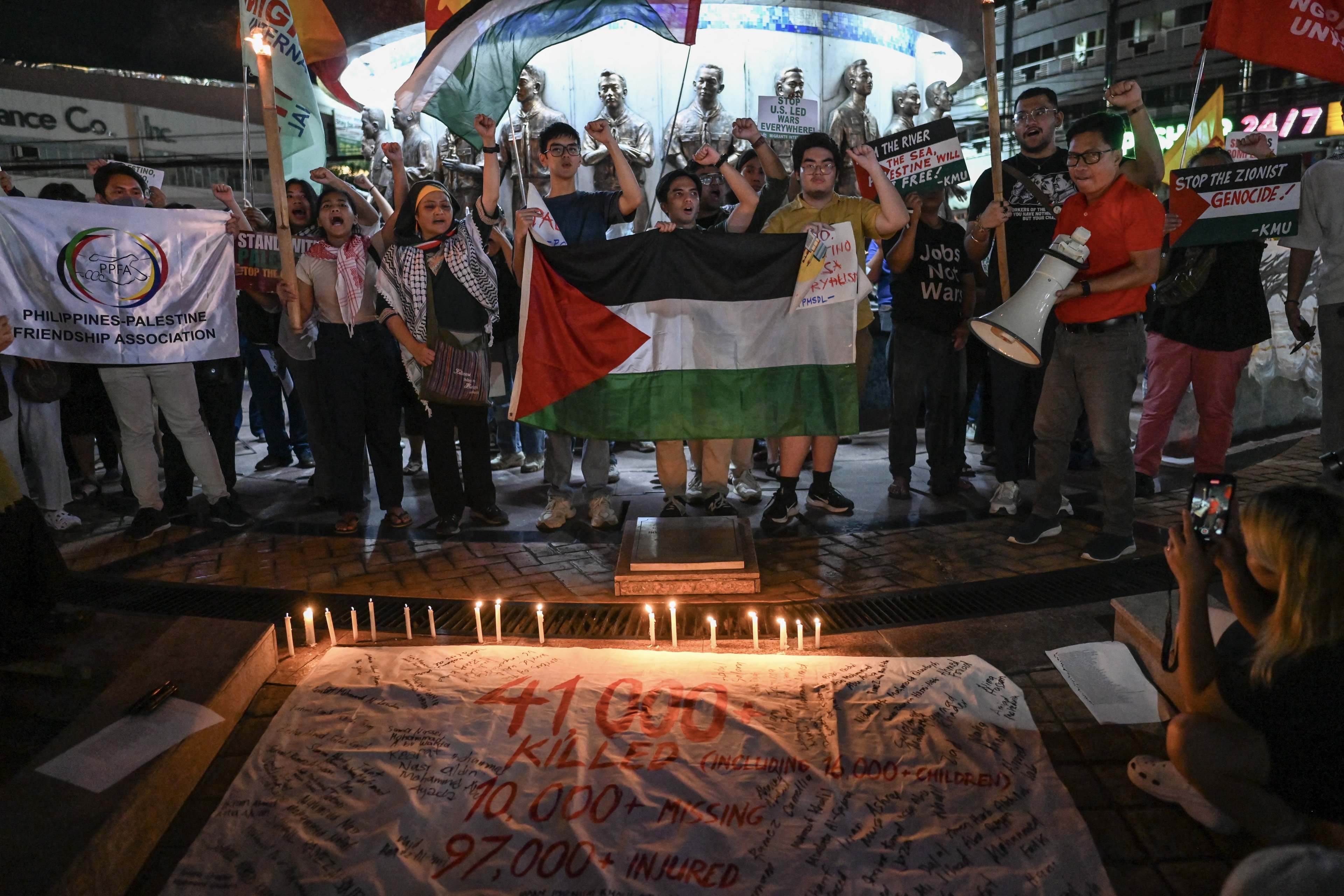 Manifestantes acendem velas e gritam slogans durante um comício pró-palestino realizado para marcar o primeiro aniversário do conflito Israel-Hamas, em Quezon City, Metro Manila, em 7 de outubro de 2024