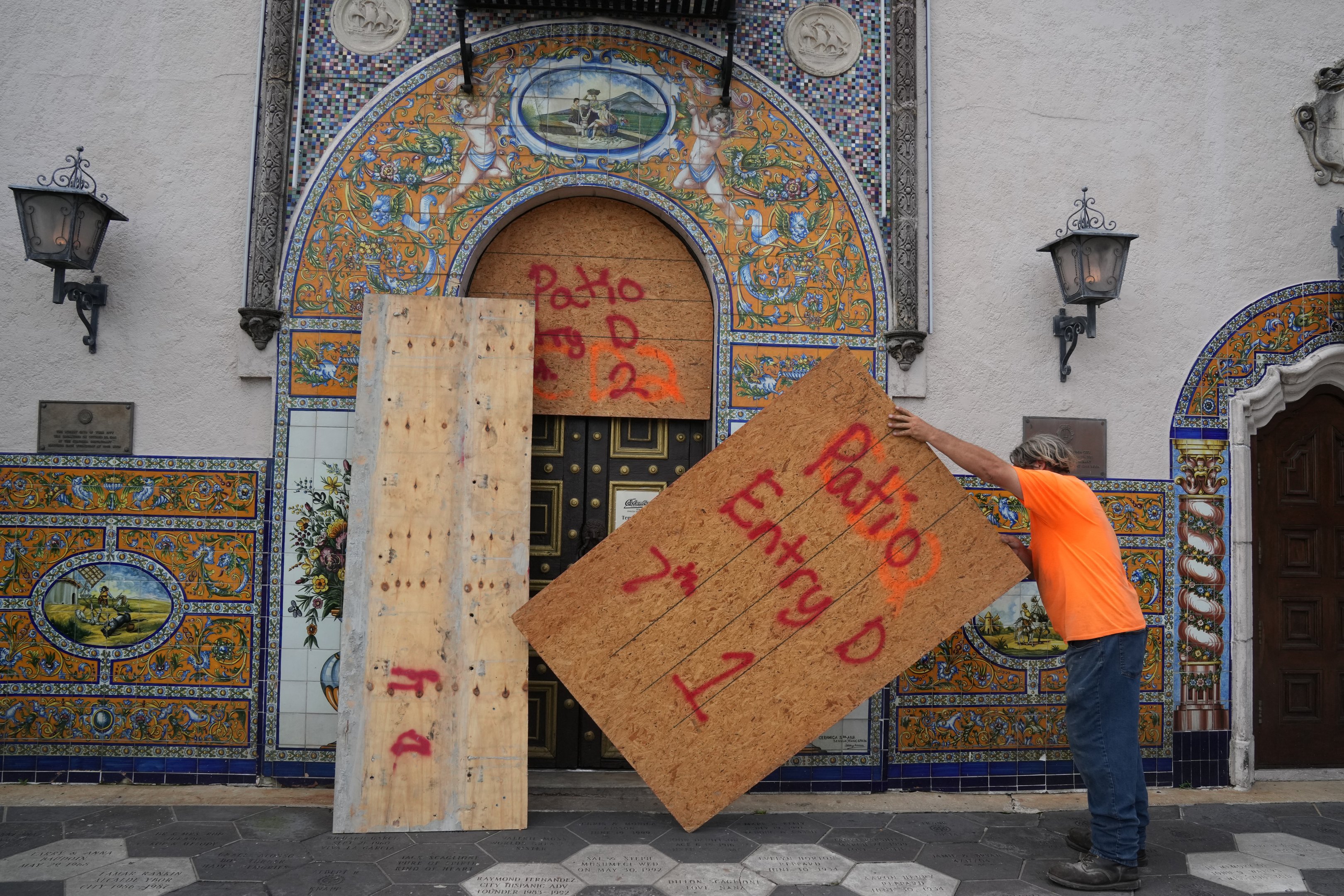 Empreiteiros colocam compensado sobre as janelas do histórico Columbia Restaurant na seção Ybor City de Tampa antes do esperado desembarque do furacão Milton no meio desta semana em 8 de outubro de 2024 na Flórida. O furacão Milton explodiu em força em 7 de outubro para se tornar uma tempestade potencialmente catastrófica de categoria 5 com destino à Flórida, ameaçando o estado dos EUA com um segundo furacão feroz em algumas semanas