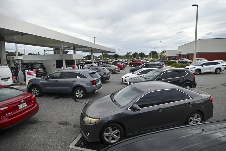 Pessoas fazem fila em seus carros para abastecer em um posto de gasolina antes da chegada esperada do furacão Milton em Lakeland, Flórida, em 8 de outubro de 2024. A Flórida atingida pela tempestade se preparou na terça-feira para um impacto direto do furacão Milton, um sistema climático monstruoso que ameaça causar danos catastróficos e força o presidente Joe Biden a adiar uma grande viagem ao exterior (Miguel J. Rodriguez Carrillo/AFP)