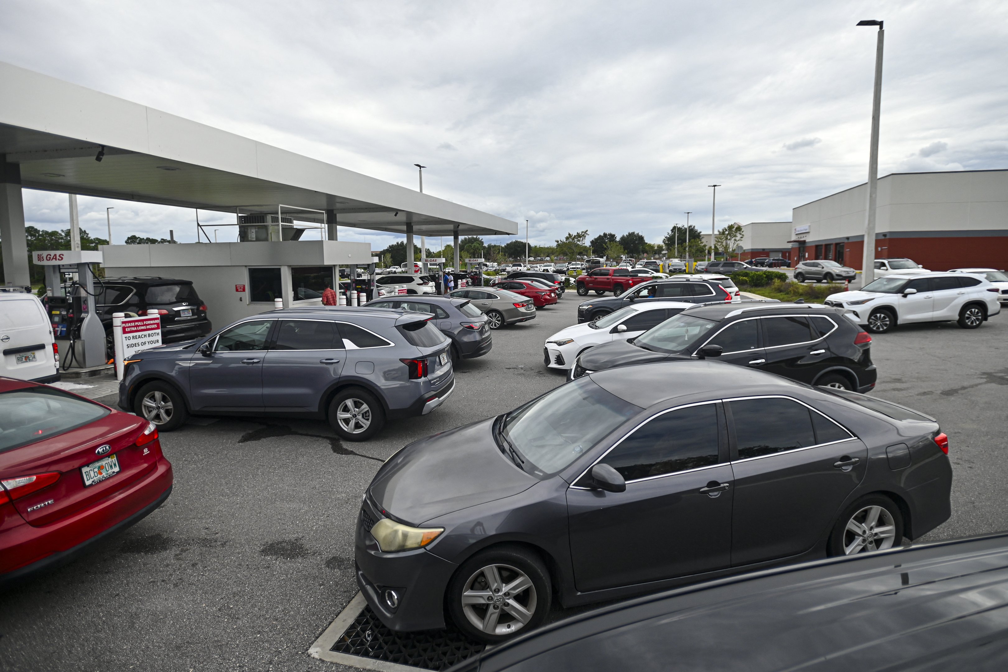 Pessoas fazem fila em seus carros para abastecer em um posto de gasolina antes da chegada esperada do furacão Milton em Lakeland, Flórida, em 8 de outubro de 2024. A Flórida atingida pela tempestade se preparou na terça-feira para um impacto direto do furacão Milton, um sistema climático monstruoso que ameaça causar danos catastróficos e força o presidente Joe Biden a adiar uma grande viagem ao exterior