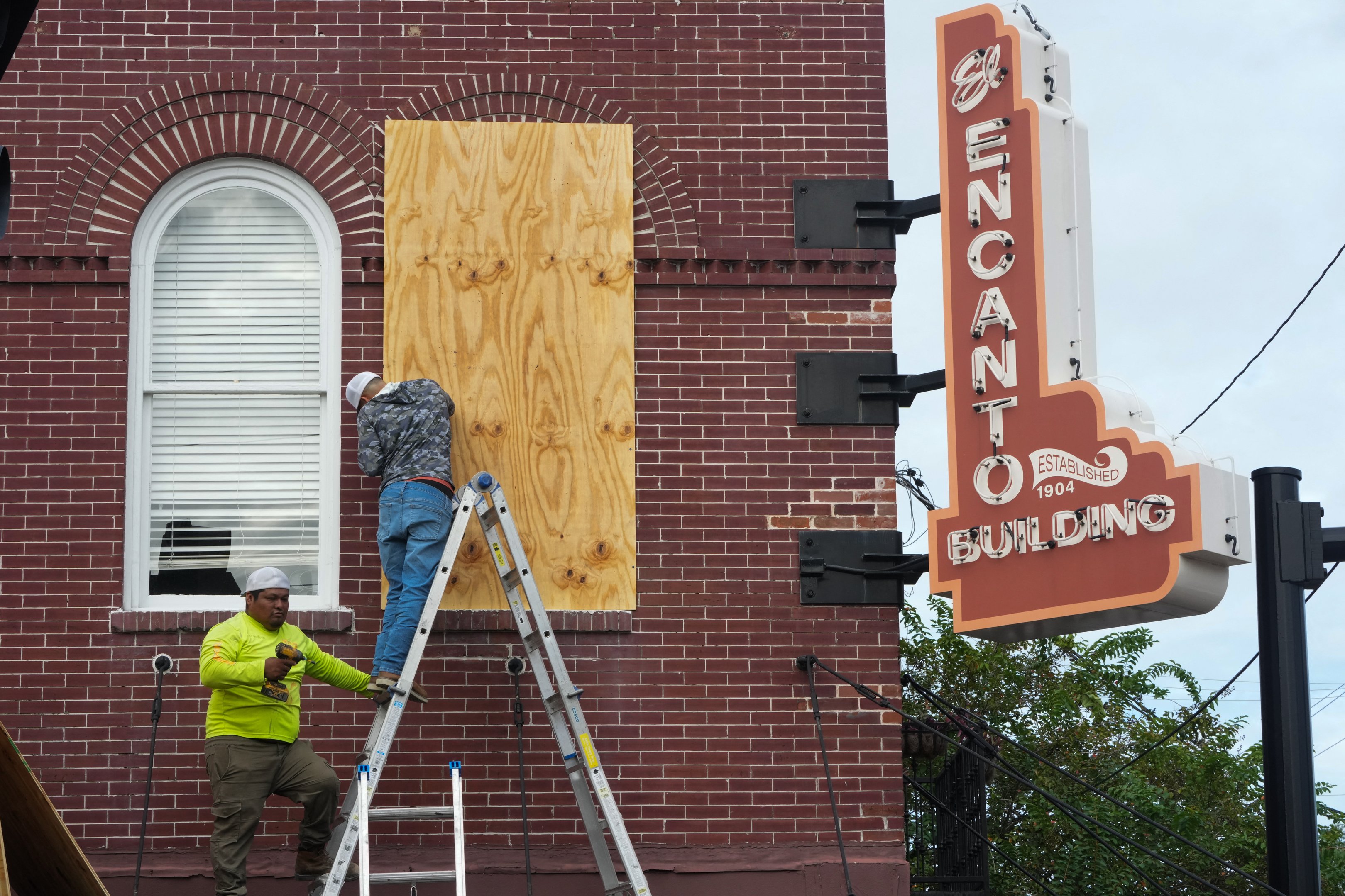 Os empreiteiros colocam compensado sobre as janelas do Edifício El Encanto na seção Ybor City de Tampa antes do esperado desembarque do furacão Milton no meio desta semana em 8 de outubro de 2024 na Flórida. O furacão Milton explodiu em força em 7 de outubro para se tornar uma tempestade potencialmente catastrófica de categoria 5 com destino à Flórida, ameaçando o estado dos EUA com um segundo furacão feroz em poucas semanas