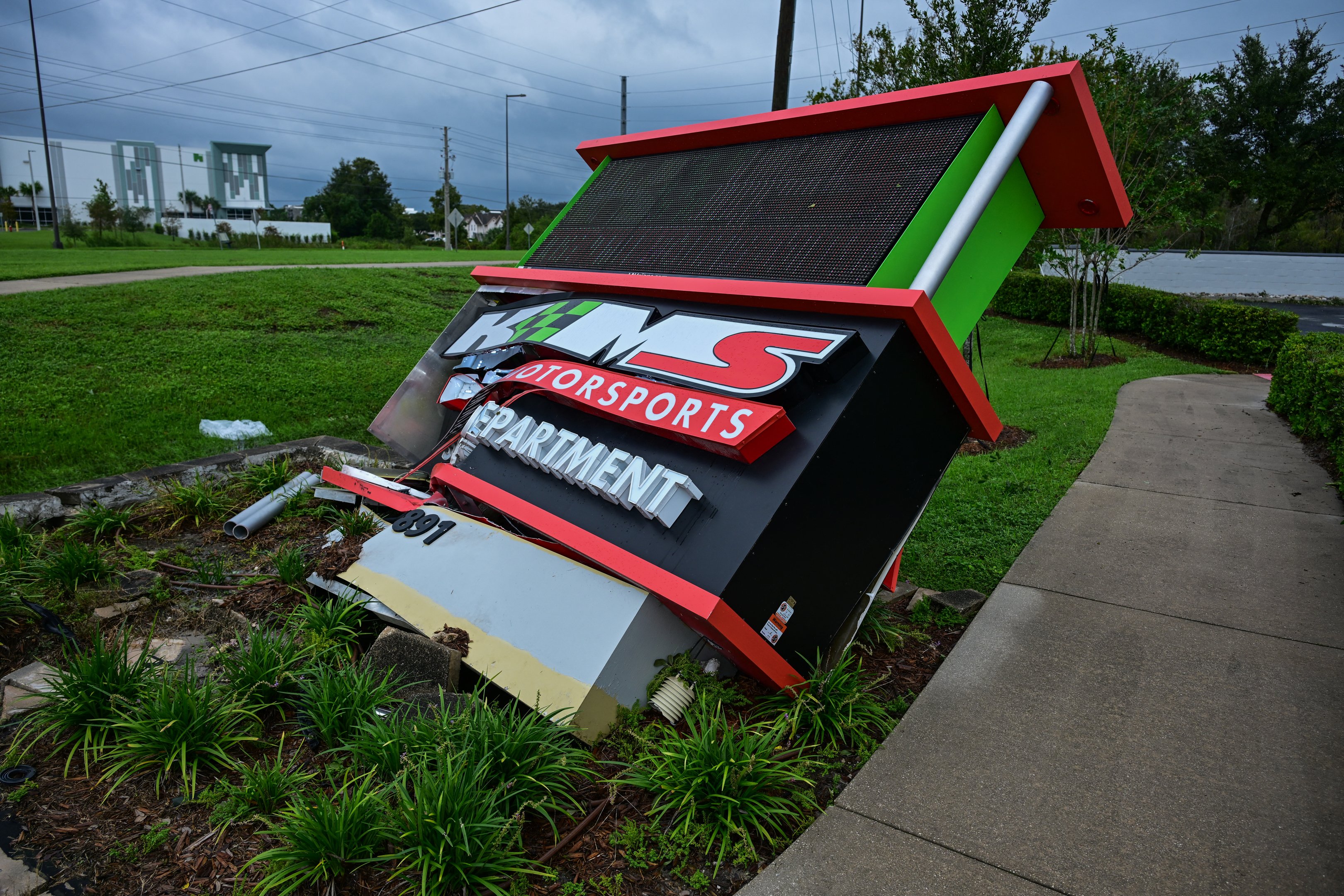 A light sign is damaged in downtown Kissimee, Florida by Hurricane Milton on October 10, 2024. At least four people were confirmed killed as a result of two tornadoes triggered by Hurricane Milton on the east coast of the US state of Florida, local authorities said Thursday. (Photo by GIORGIO VIERA / AFP)