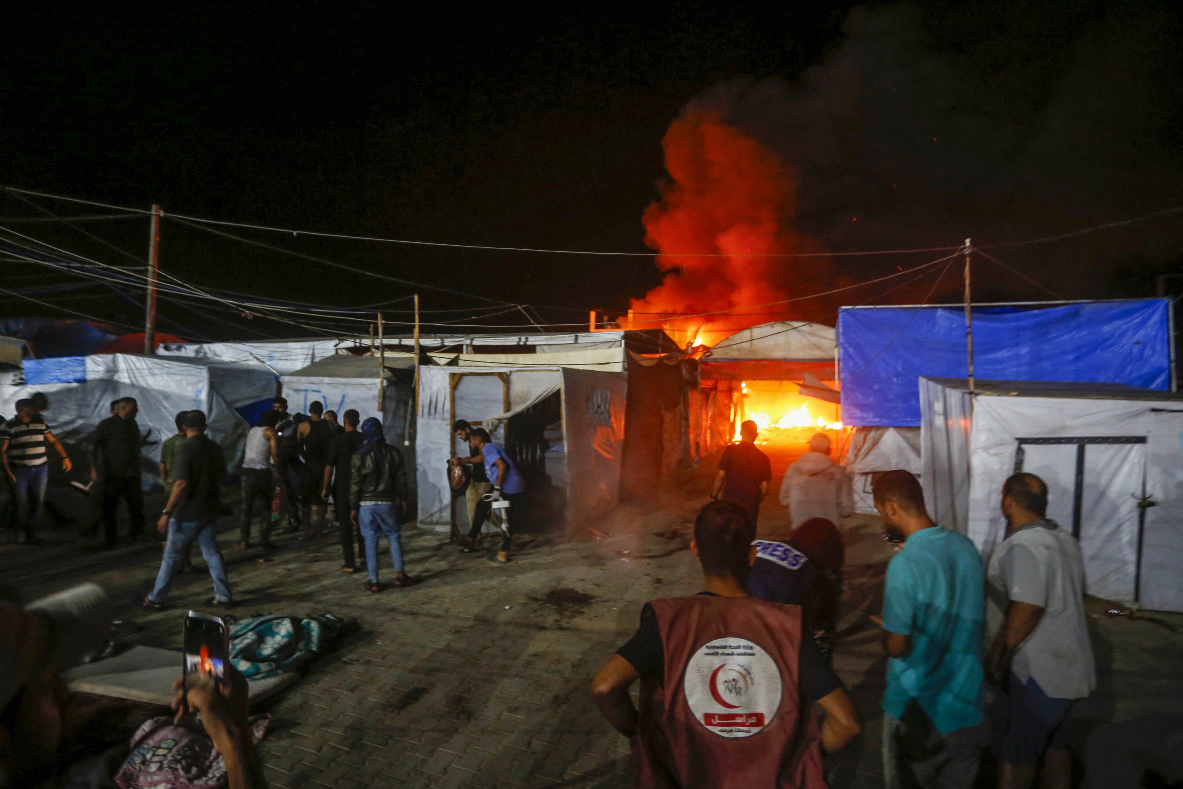 Esta foto fornecida pela Agência das Nações Unidas de Assistência e Obras para os Refugiados da Palestina no Oriente Próximo (UNRWA) mostra pessoas no local de um ataque aéreo israelense em torno de tendas para pessoas deslocadas dentro dos muros do Hospital dos Mártires de Al-Aqsa, em Deir al. -Balah, no centro da Faixa de Gaza no início de 14 de outubro de 2024