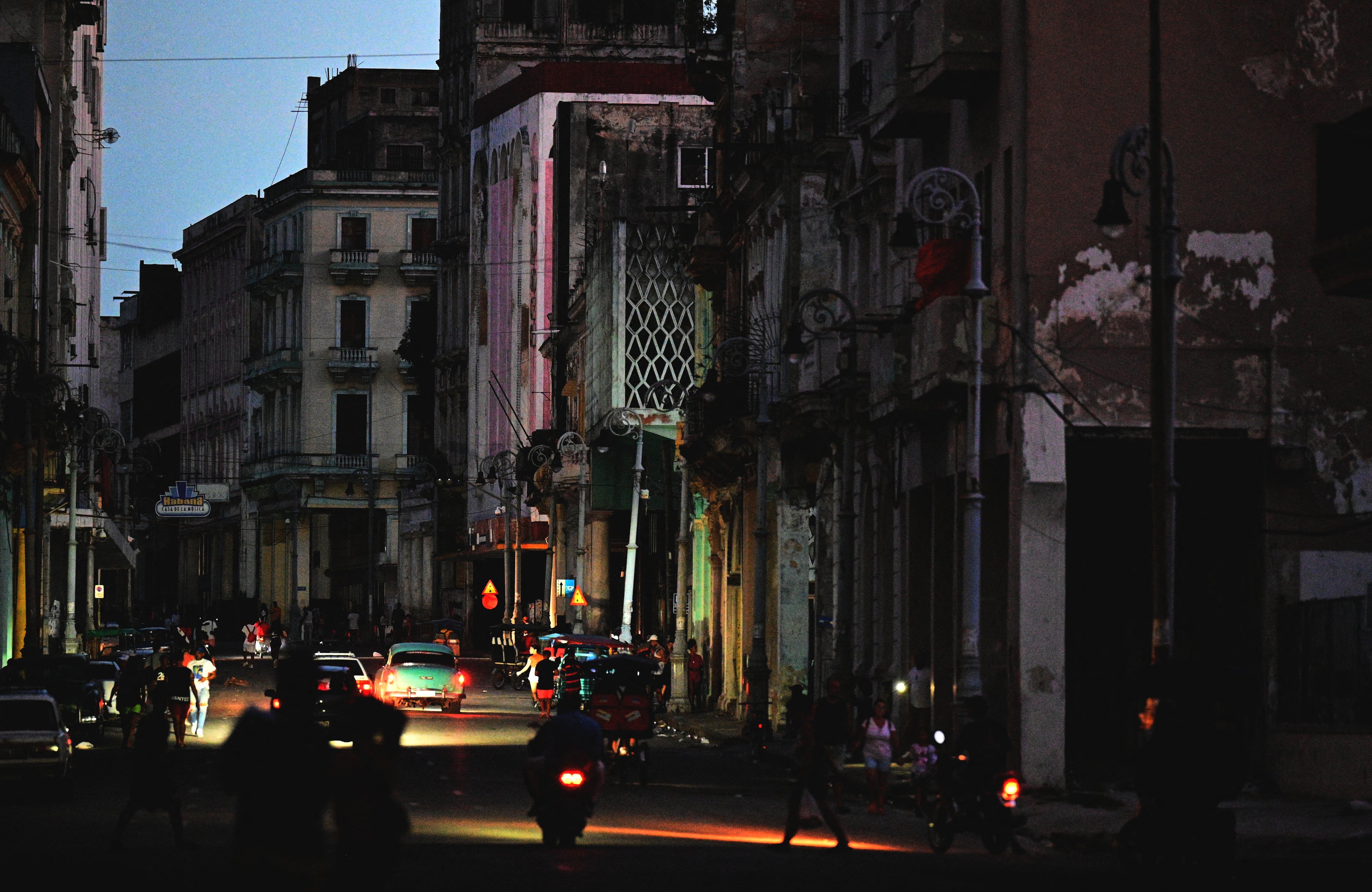 Uma rua é iluminada por luzes de carros durante a terceira noite de um apagão nacional em Havana, em 20 de outubro de 2024. O presidente cubano Miguel Díaz-Canel alertou no domingo que agirá com "rigor" contra aqueles que tentarem perturbar a ordem pública, em meio a um apagão total que manteve a ilha na escuridão por três noites