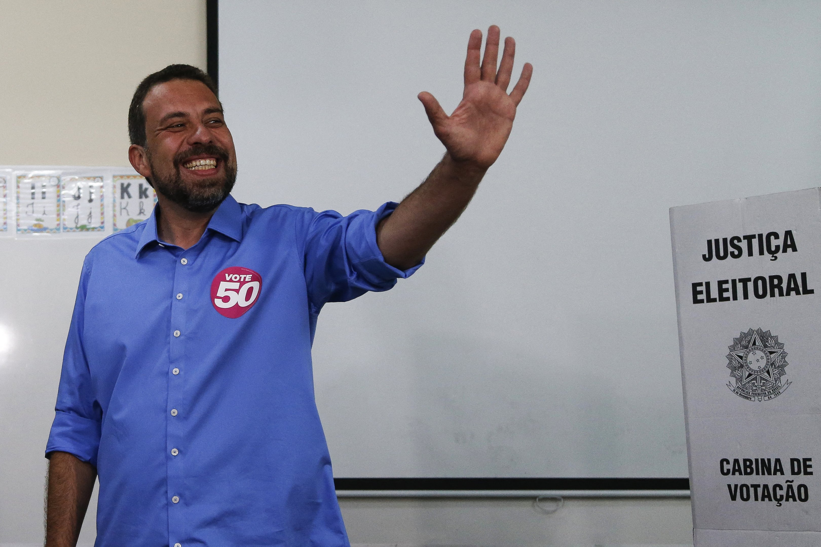 Sao Paulo city mayoral candidate Guilherme Boulos, for the Socialismo e Liberdade party (PSOL), waves while voting during the municipal elections second round in Sao Paulo, Brazil, on October 27, 2024. (Photo by Miguel SCHINCARIOL / AFP)