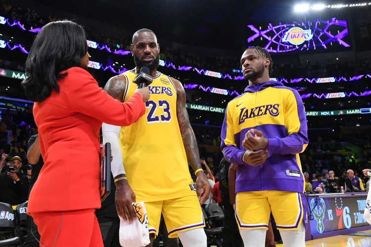 LeBron e Bronny James entram em quadra juntos pela primeira vez, fazendo história na NBA como a primeira dupla de pai e filho a jogar na liga. (Allen Berezovsky/AFP)