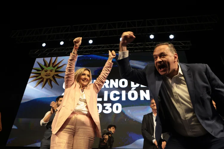 O candidato à Presidência do Uruguai pelo Partido Nacional, Álvaro Delgado, e sua candidata presidencial, Valeria Ripoll, cumprimentam seus apoiadores, neste domingo em Montevidéu (Uruguai) (Gaston Britos/EFE)