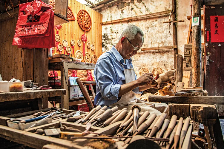 Artesão na vila Zhuge Liang Bagua: cerca de 4 mil moradores vivem do turismo e da atividade, cujo processo humano segue como diferencial (Leandro Fonseca/Exame)