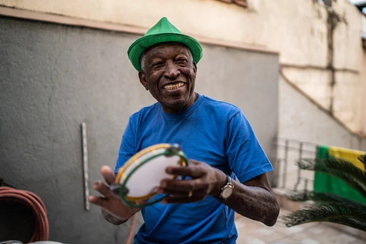 Senior man playing tambourine at home (FG Trade/Getty Images)