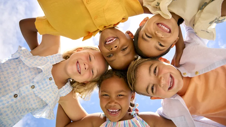 Group Of Multi-Cultural Children Friends Linking Arms Looking Down Into Camera (	monkeybusinessimages/Getty Images)