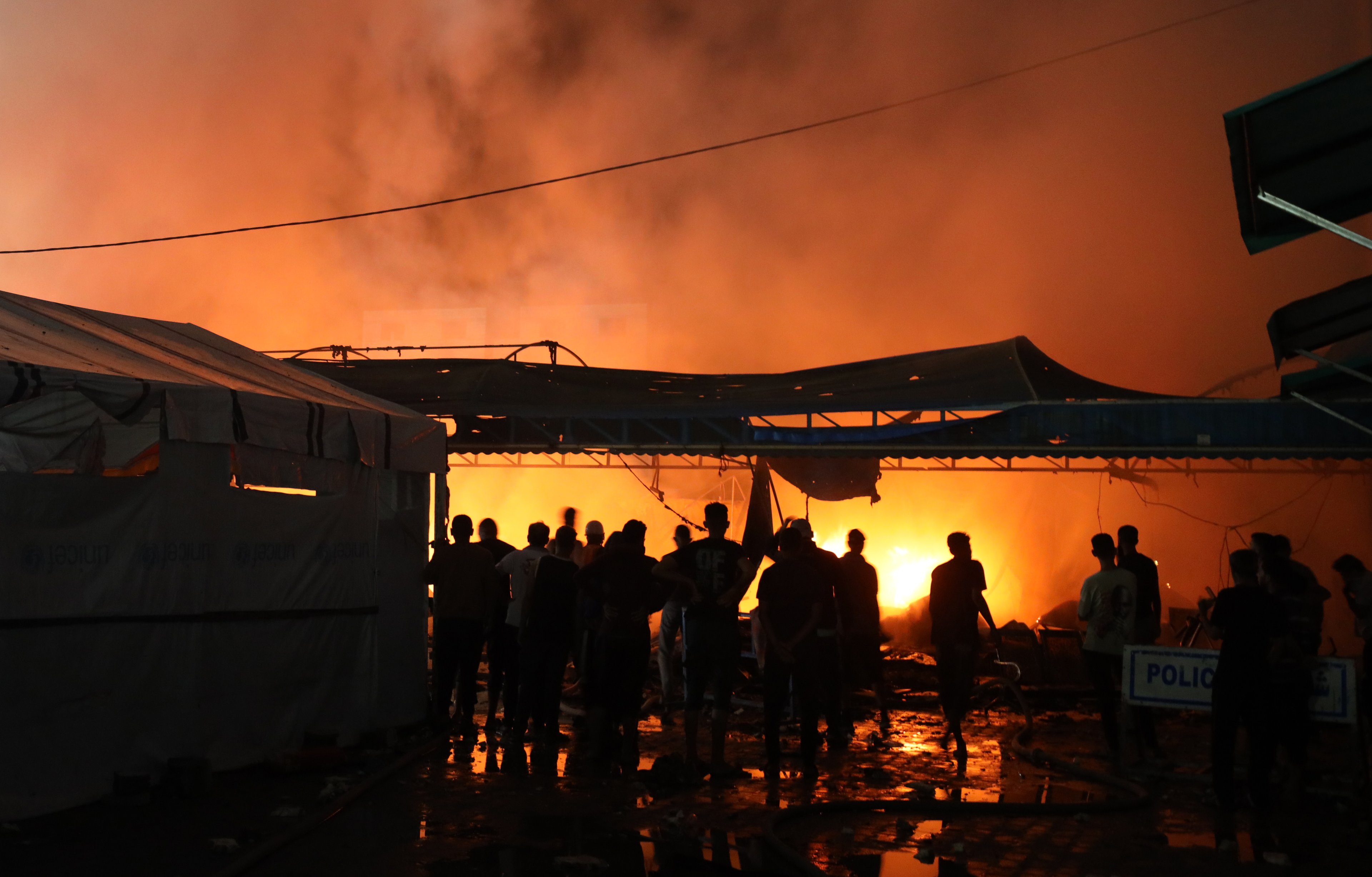 Pessoas tentam extinguir um incêndio no local de um ataque israelense a tendas que abrigavam pessoas deslocadas em meio ao conflito Israel-Hamas em Deir Al-Balah, Faixa de Gaza, em 14 de outubro de 2024