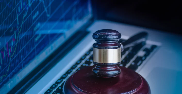 Judges gavel on keyboard with glowing computer screen monitor background. (BCFC/Getty Images)