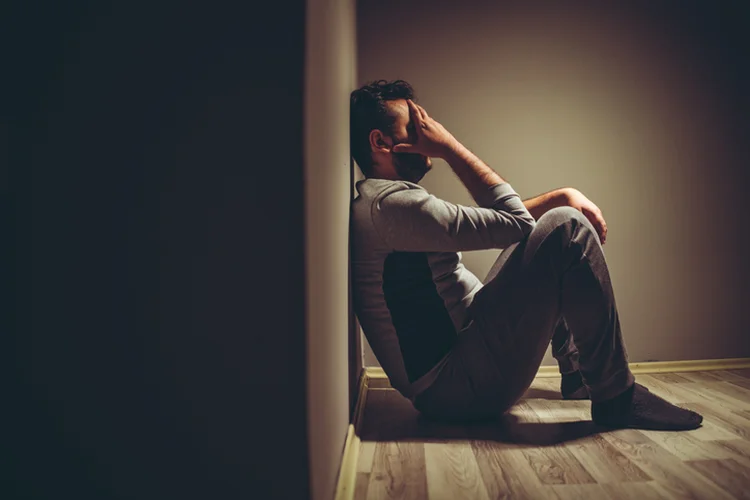 Young depressed man sitting on floor. (urbazon/Getty Images)