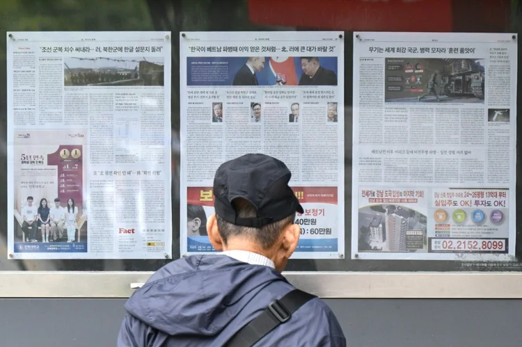 Homem observa jornais em Seul com a cobertura da decisão da Coreia do Norte de enviar milhares de soldados para a Rússia (AFP)