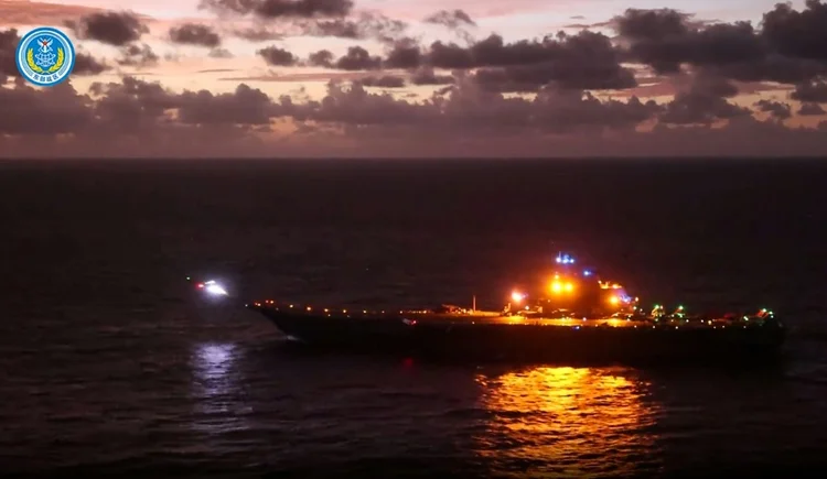 Captura de tela de vídeo do Exército chinês em que um caça pousa no porta-aviões Liaoning durante manobras ao redor de Taiwan, em 14 de outubro de 2024 (AFP)