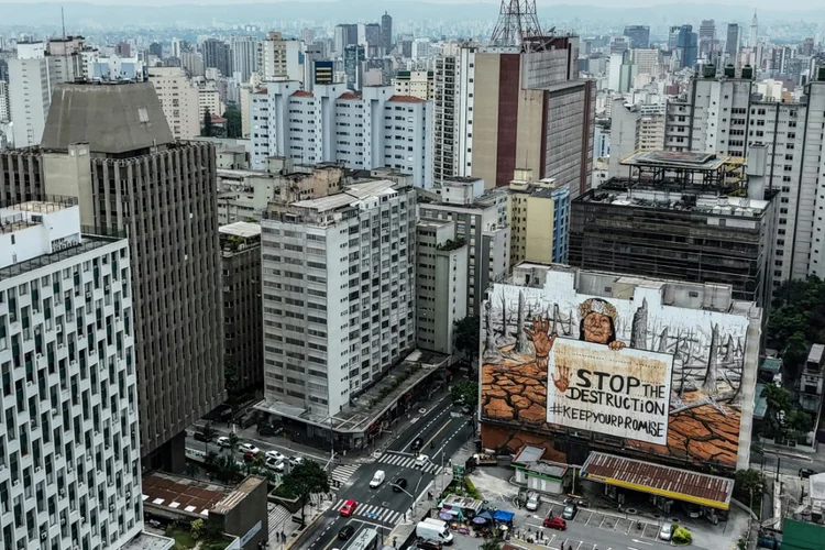 Vista aérea de um enorme mural de rua criado pelo artista brasileiro Mundano e feito com cinzas de incêndios florestais e lama de enchentes para destacar eventos climáticos extremos que causam estragos em todo o país em São Paulo, Brasil, em 23 de outubro de 2024 (AFP)