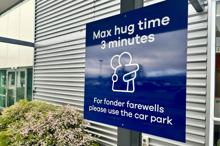 Placa no aeroporto de Dunedin, Nova Zelândia, determina o limite de três minutos para abraços de despedidas (AFP)