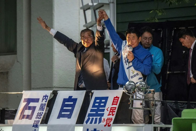 O primeiro-ministro japonês, Shigeru Ishiba (esquerda), participa de comício de seu partido em Tóquio antes das eleições legislativas. (AFP/AFP)