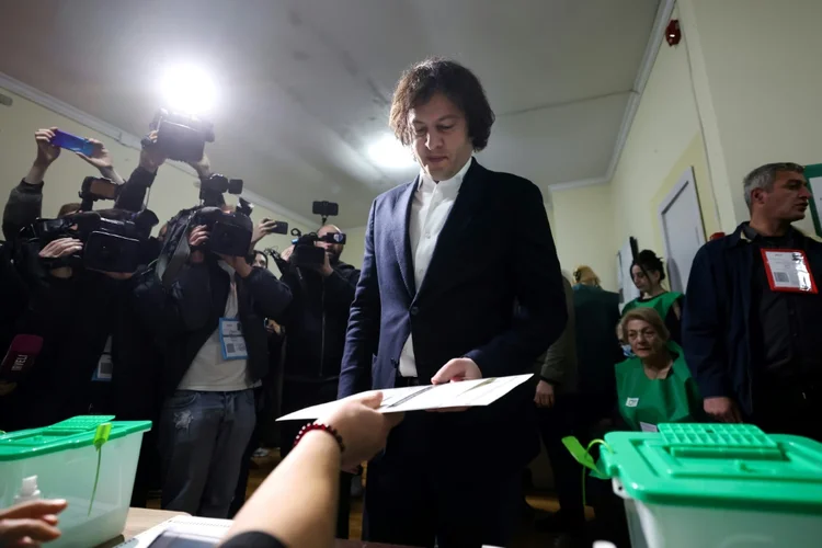 O primeiro-ministro georgiano, Irakli Kobajidze, vota para as eleições parlamentares em uma seção eleitoral em Tbilisi, em 26 de outubro de 2024 (AFP)