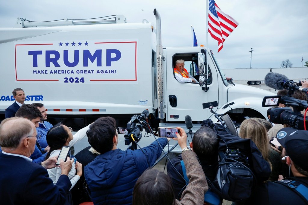 Trump sobe em caminhão de lixo durante campanha como resposta à provocação de Joe Biden