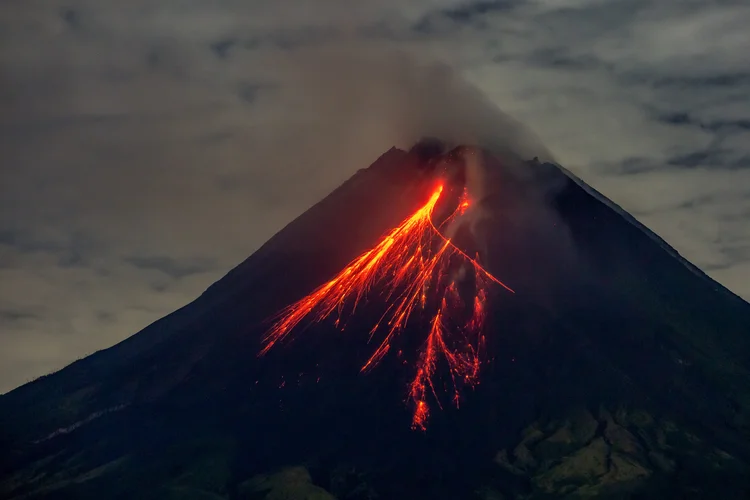 O Monte Merapi expele lava em suas encostas durante uma erupção, vista da vila de Srumbung em Magelang, Java Central, em 4 de novembro de 2024 (DEVI RAHMAN /AFP)