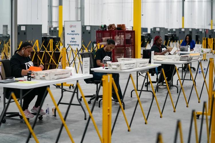 Trabalhadores eleitorais do Condado de Fulton processam cédulas de votação ausentes no novo Centro Eleitoral e Centro de Operações do Condado de Fulton em 4 de novembro de 2024 em Union City, Geórgia (Elijah Nouvelage /AFP)