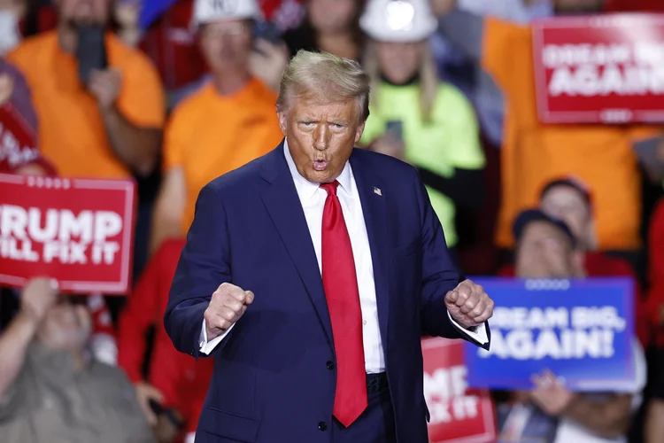 Donald Trump, presidente eleito dos EUA, dança enquanto sobe ao palco durante um comício de campanha na Van Andel Arena em Grand Rapids, Michigan, em 5 de novembro de 2024 (KAMIL KRZACZYNSKI /AFP)