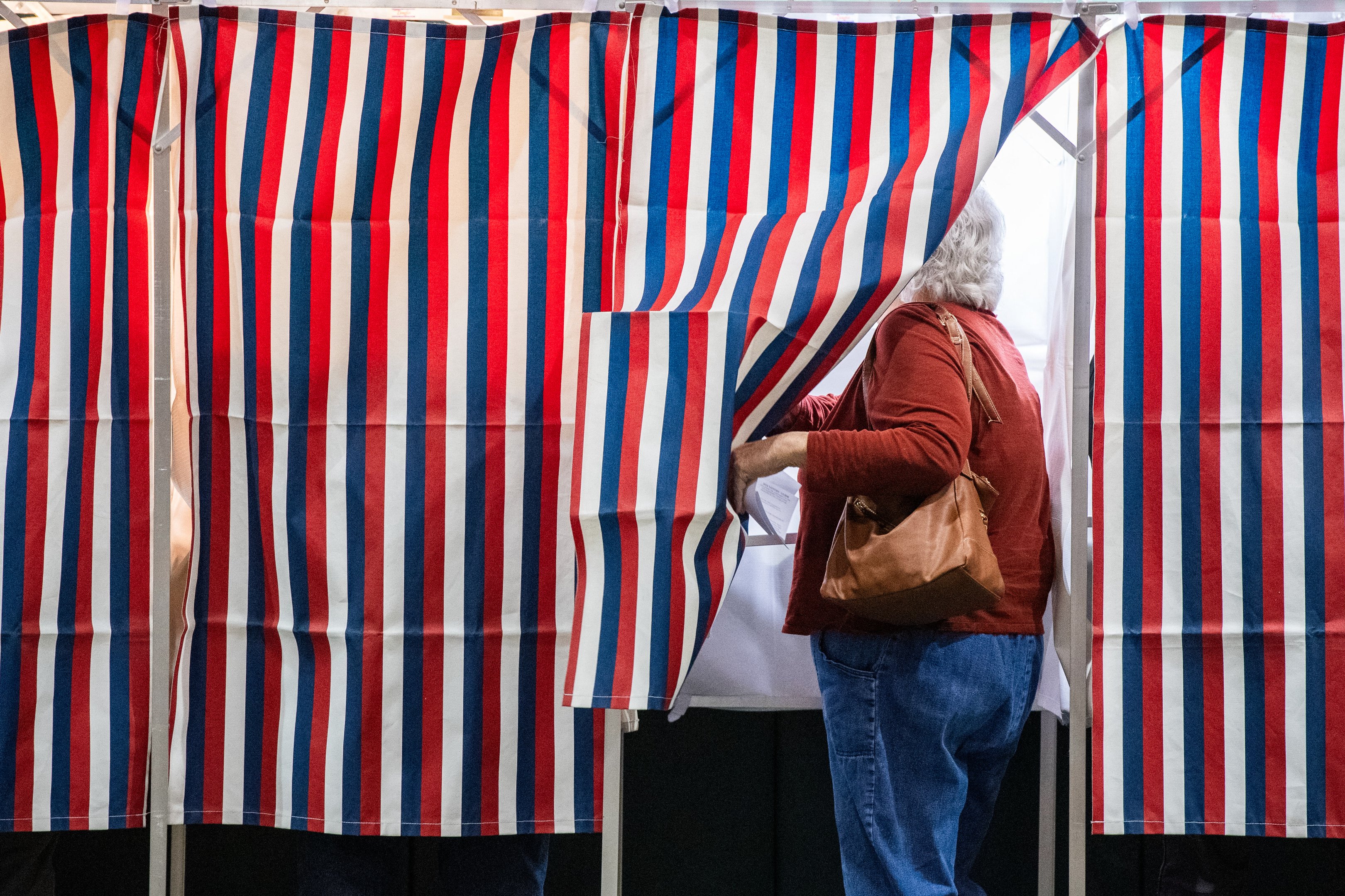 A person enters a voting booth at a polling station at Colebrook Academy and Elementary School in Colebrook, New Hampshire, on Election Day, November 5, 2024. (Photo by Joseph Prezioso / AFP)