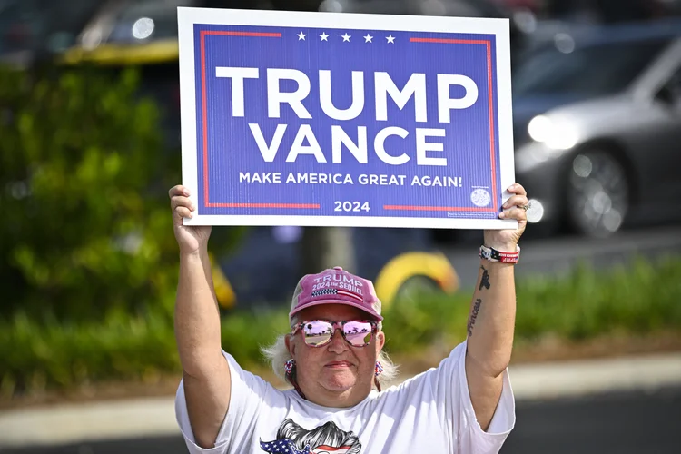 Um apoiador do ex-presidente dos EUA e candidato presidencial republicano Donald Trump segura uma placa no dia da eleição, em The Villages, Flórida, 5 de novembro de 2024 (Miguel J. Rodriguez Carrillo/AFP)