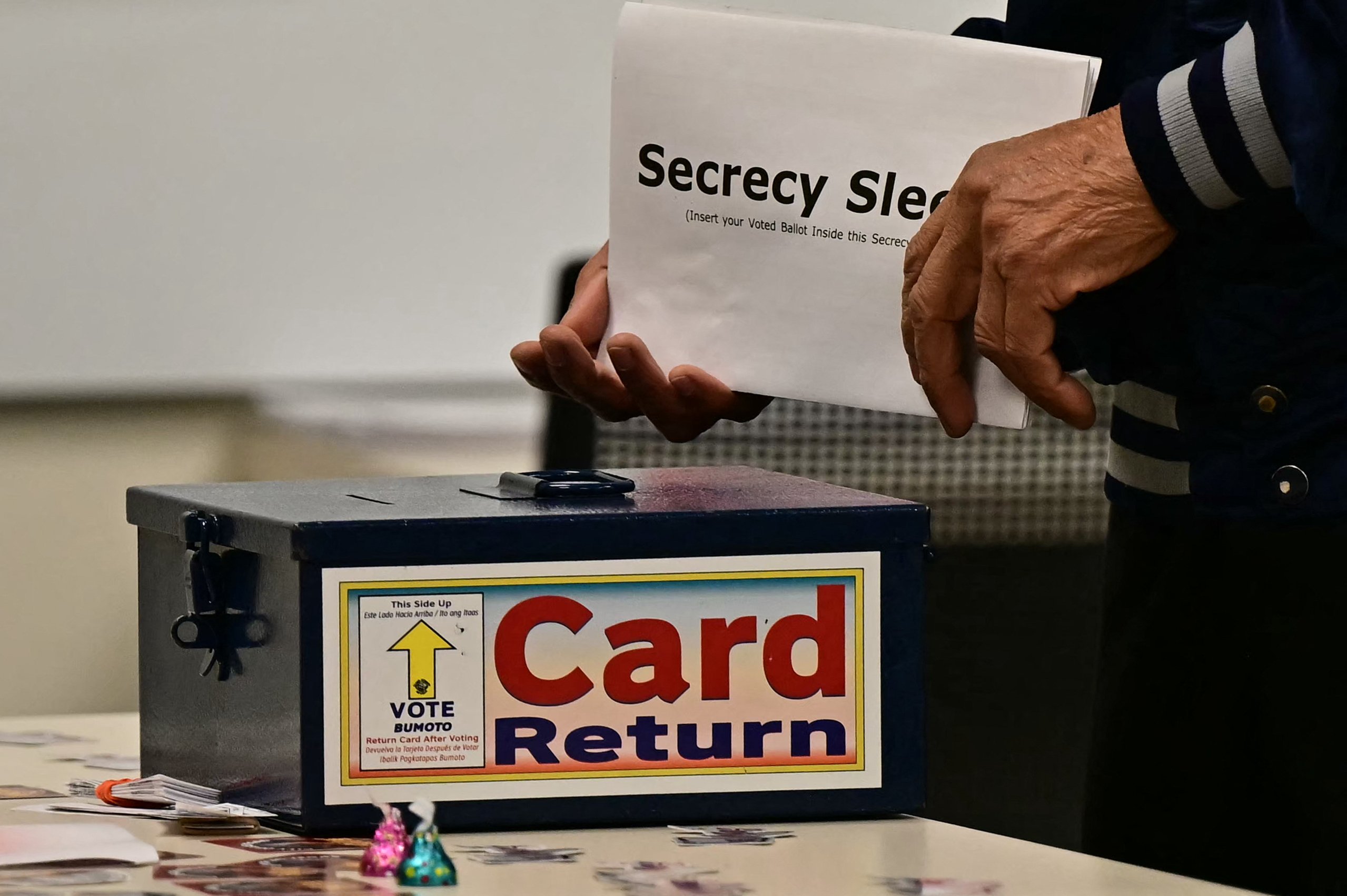 A voter carries his ballot card in a "secrecy sleeve" at a polling station at Las Vegas City Hall in Las Vegas, Nevada, on Election Day, November 5, 2024. (Photo by Frederic J. Brown / AFP)