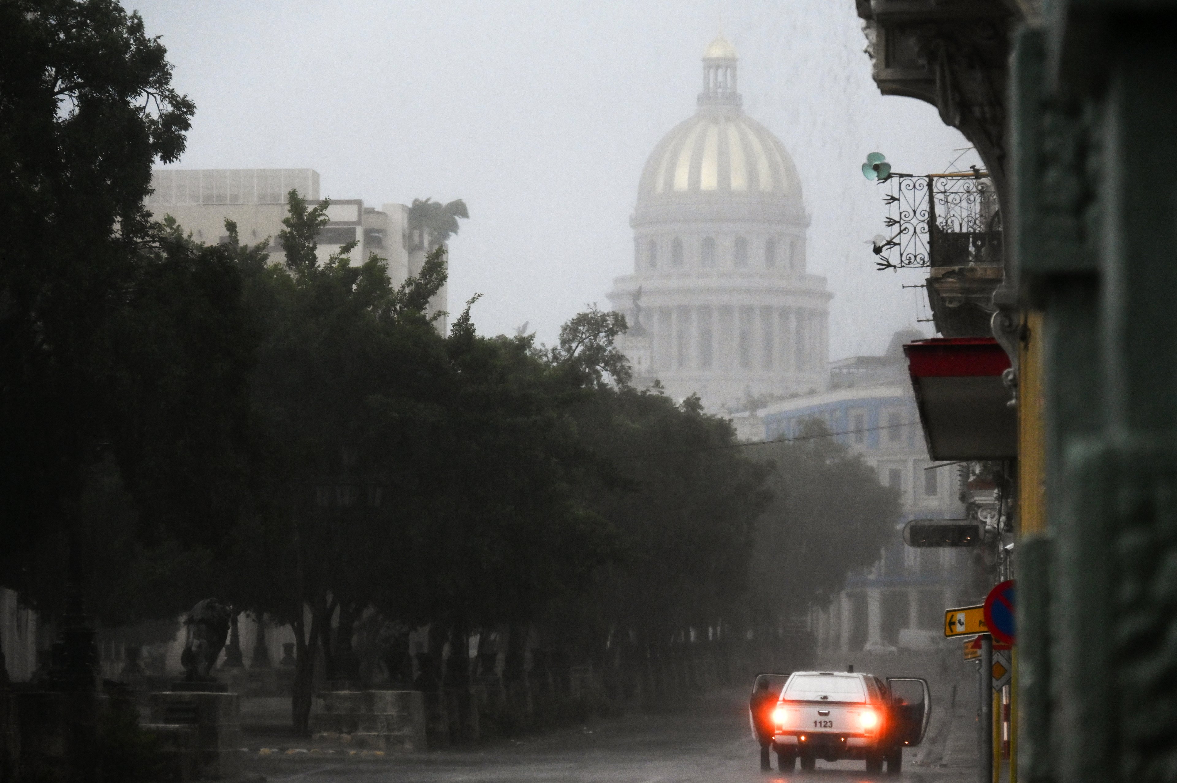 Um carro para em uma rua após a chegada do furacão Rafael em Havana em 6 de novembro de 2024. O furacão Rafael cortou a energia de toda Cuba na quarta-feira ao atingir a ilha, que ainda se recupera de um apagão recente e de uma grande tempestade anterior, disse a empresa nacional de energia