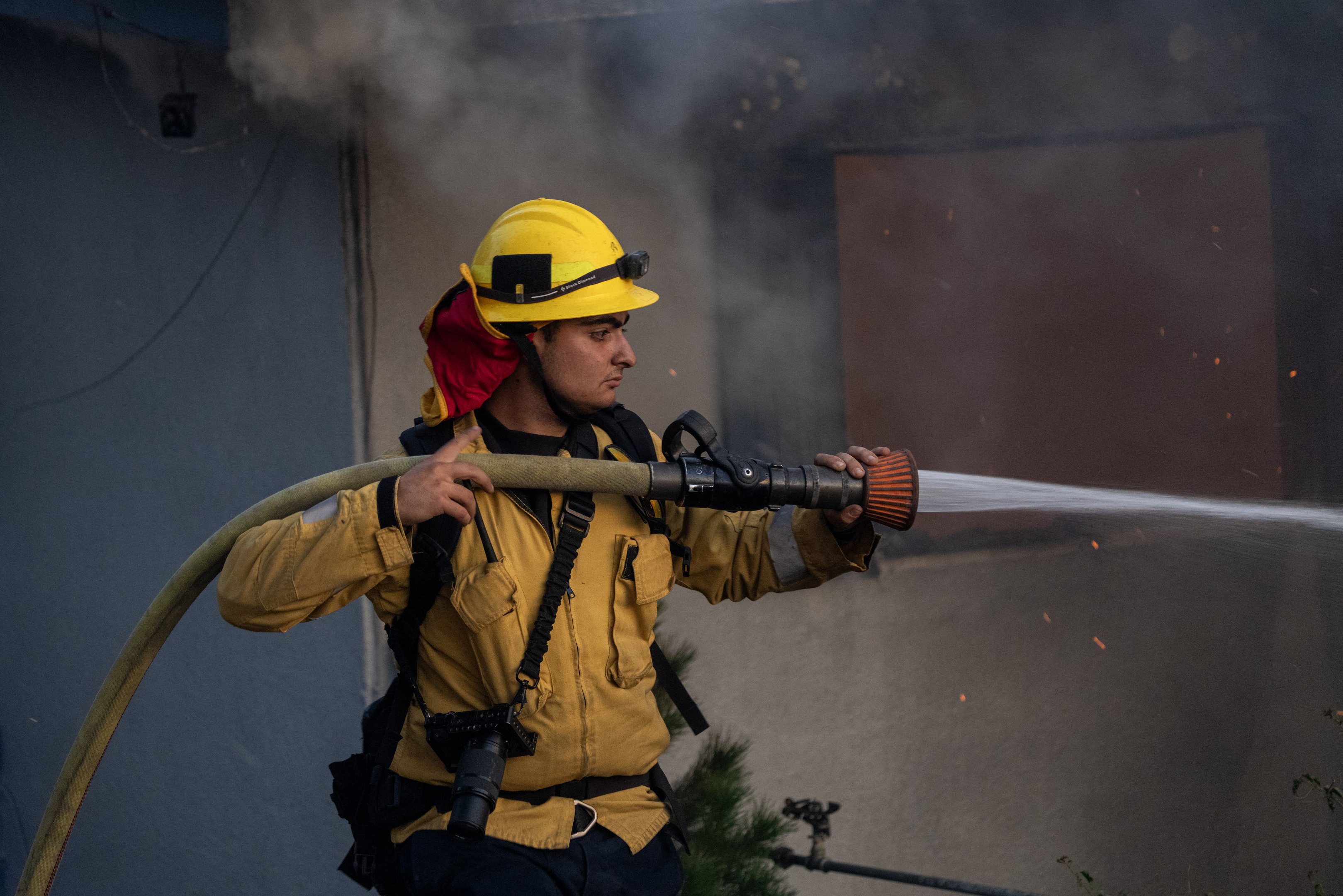 Um bombeiro do Condado de Los Angeles luta contra as chamas enquanto uma casa queima no Mountain Fire em 6 de novembro de 2024 em Camarillo, Califórnia. Impulsionado por ventos fortes, o fogo queimou mais de 10.000 acres desde que começou esta manhã