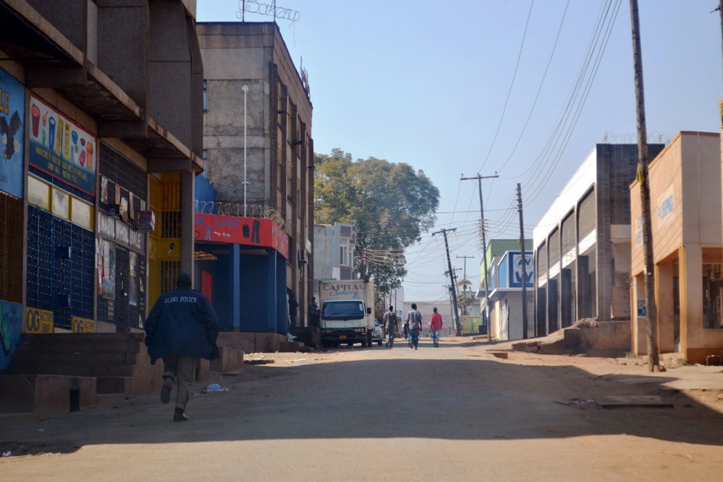 A Malawian police man walks down the deserted streets of Lilongwe, on July 21, 2011, a day after mass protests against Malawi's President Bingu wa Mutharika. Eighteen people have died across Malawi after two days of violent protests that degenerated into looting and running battles with security forces, a health ministry spokesman said. AFP PHOTO / Stringer (Photo credit should read STRINGER/AFP via Getty Images)