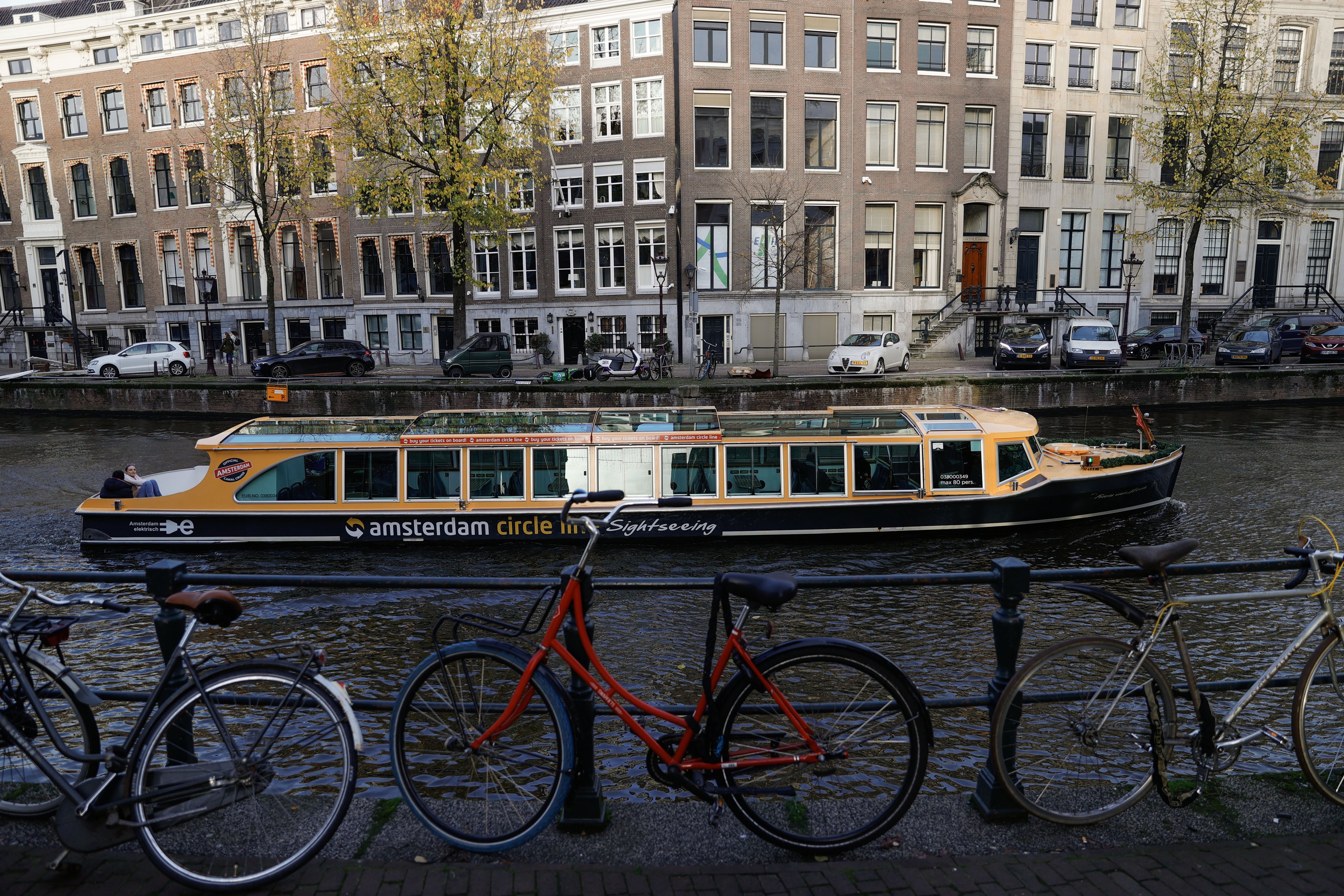 AMSTERDAM, NETHERLANDS - NOVEMBER 24: A city sightseeing boat is seen on a canal during daily life in Amsterdam, Netherlands on November 24, 2024. The city attracts tourists with its historical buildings and canals running through the city