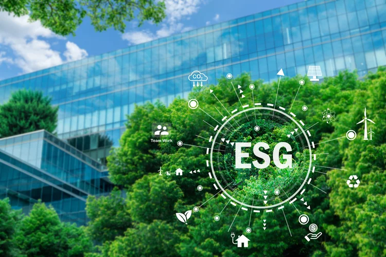 ESG concept. Eco-friendly building in modern city. Sustainable glass office building with tree for reducing carbon dioxide. Office building with green environment. Corporate building use clean energy.