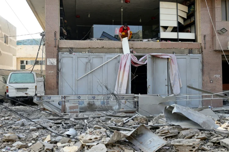Um homem remove destroços de uma loja danificada por um ataque aéreo israelense noturno em um bairro ao sul de Beirute, em 1º de novembro de 2024, na capital libanesa (AFP)