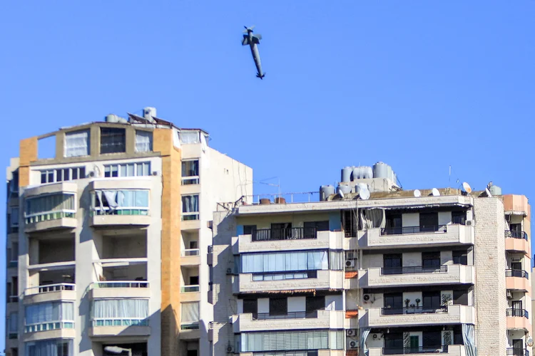 Um foguete disparado por um avião de guerra israelense se aproxima de um prédio no subúrbio de Shiyah, no sul de Beirute, em 22 de outubro de 2024, em meio à guerra entre Israel e o Hezbollah. (AFP)