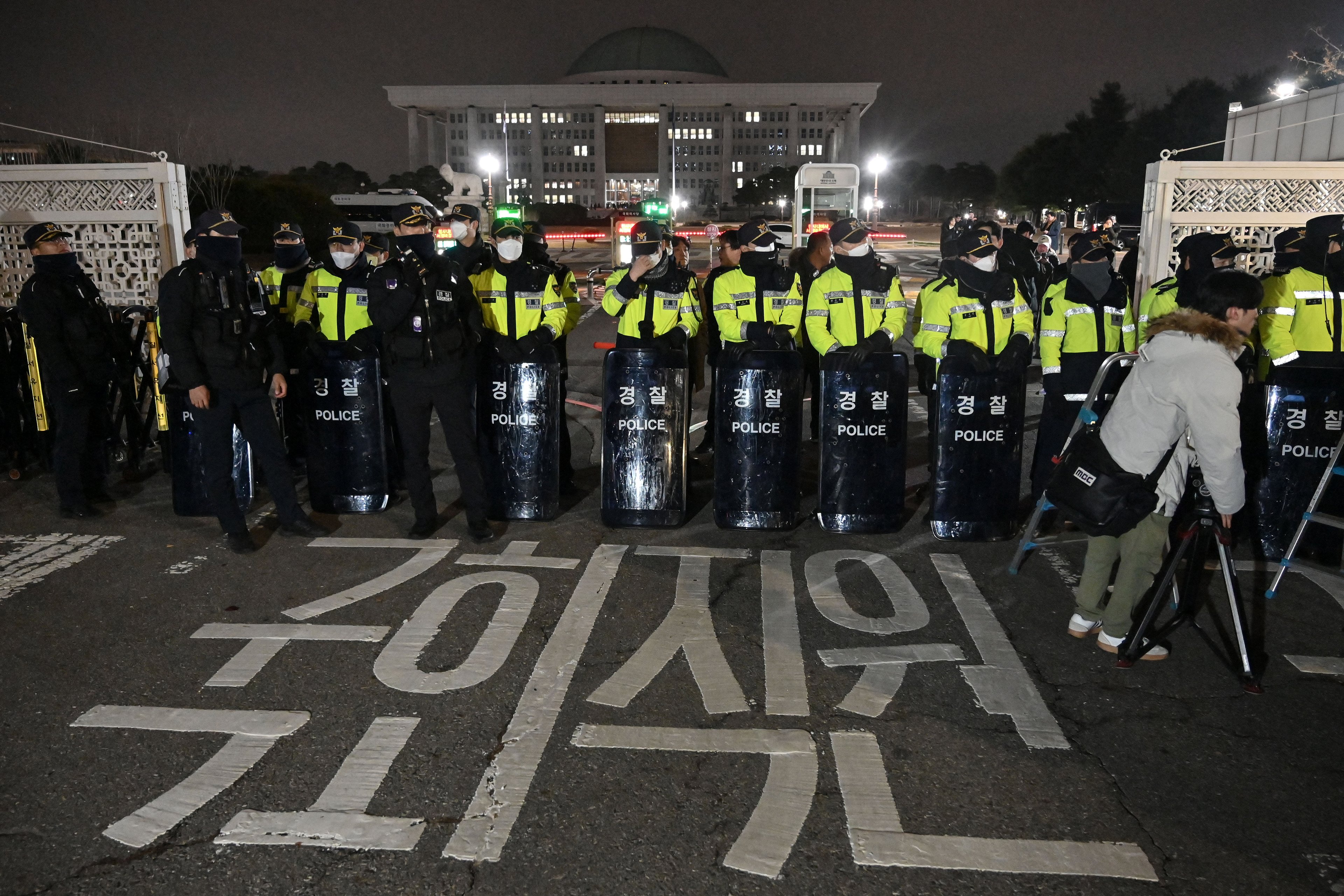 A polícia monta guarda em frente ao portão principal da Assembleia Nacional em Seul, Coreia do Sul, em 3 de dezembro de 2024, depois que o presidente Yoon Suk Yeol declarou lei marcial de emergência. O presidente da Coreia do Sul, Yoon Suk Yeol, declarou lei marcial de emergência em 3 de dezembro, dizendo que a medida era necessária para proteger o país das "forças comunistas" em meio a disputas parlamentares sobre um projeto de lei orçamentária