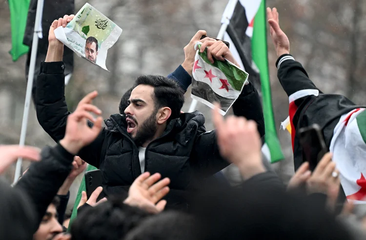 Members of the Syrian community wave Syrian flags on December 8, 2024 in Berlin, Germany, and celebrate the end of Syrian dictator Bashar al-Assad's rule after rebel fighters took control of the Syrian capital Damascus overnight. Islamist-led rebels toppled Syria's longtime ruler Bashar al-Assad in a lightning offensive that a UN envoy called "a watershed moment" for the nation marred by civil war. (Photo by RALF HIRSCHBERGER / AFP) (RALF HIRSCHBERGER / AFP/AFP)