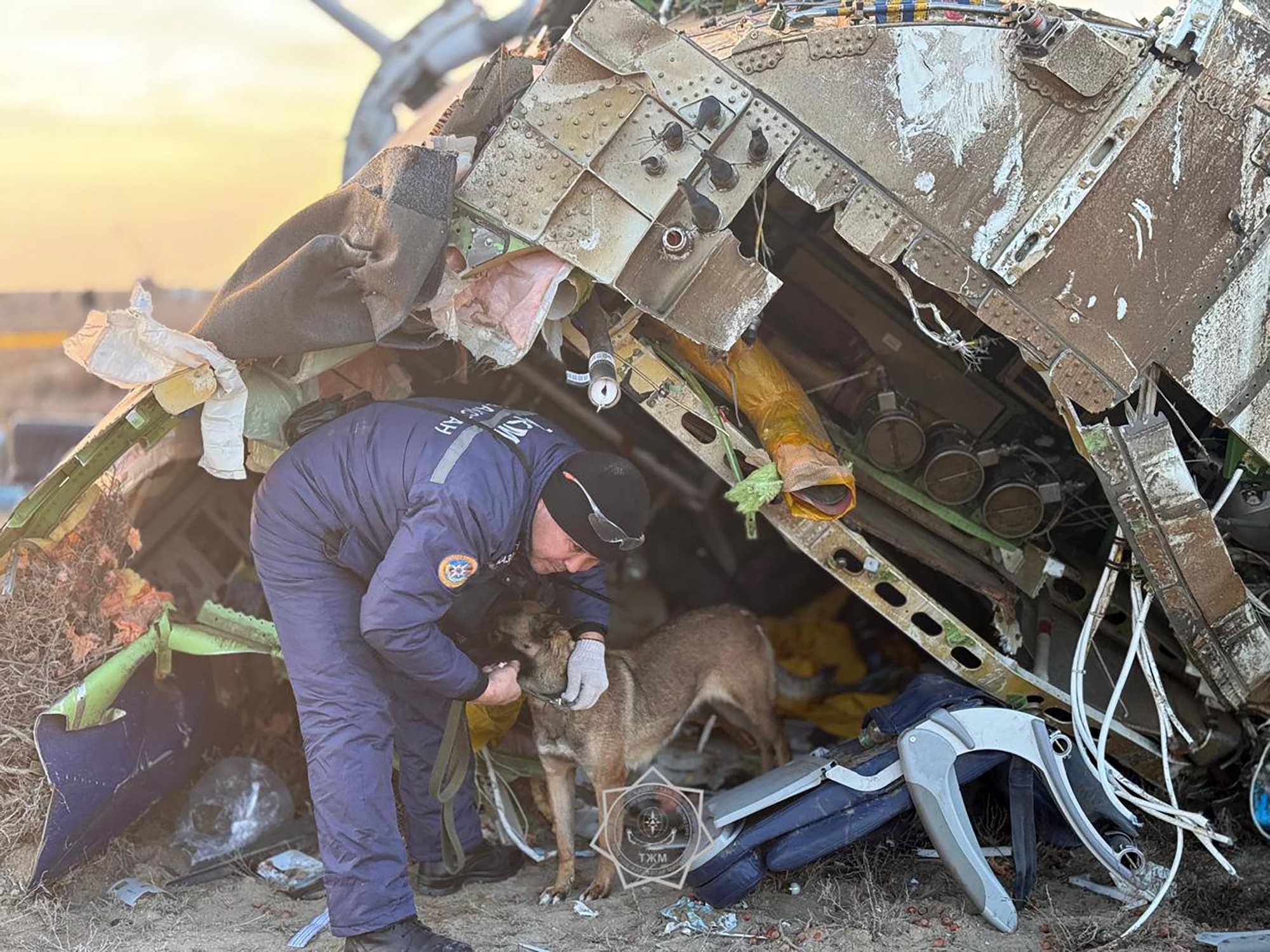 In this handout picture released by Kazakhstan's emergency situations ministry on December 26, 2024, emergency specialists work at the crash site of an Azerbaijan Airlines passenger jet near the western Kazakh city of Aktau. (Photo by Handout / Kazakhstan's emergency situations ministry / AFP) / RESTRICTED TO EDITORIAL USE - MANDATORY CREDIT "AFP PHOTO / Kazakhstan's emergency situations ministry / handout" - NO MARKETING NO ADVERTISING CAMPAIGNS - DISTRIBUTED AS A SERVICE TO CLIENTS