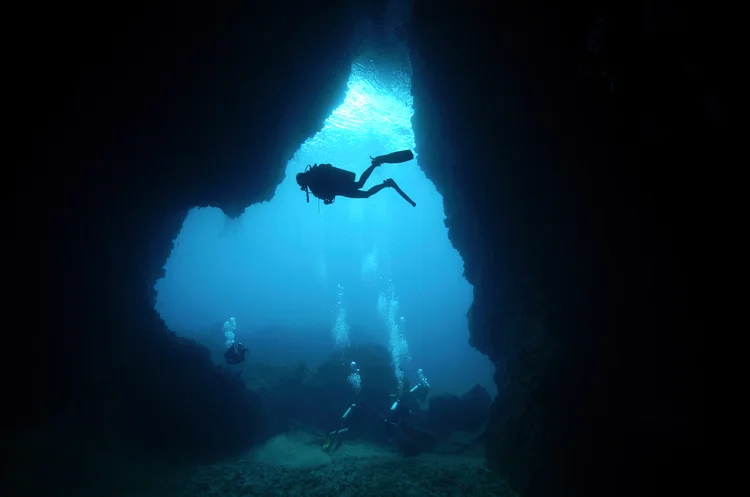 View of shadow of diver at an entrance of cave (kampee patisena/Getty Images)