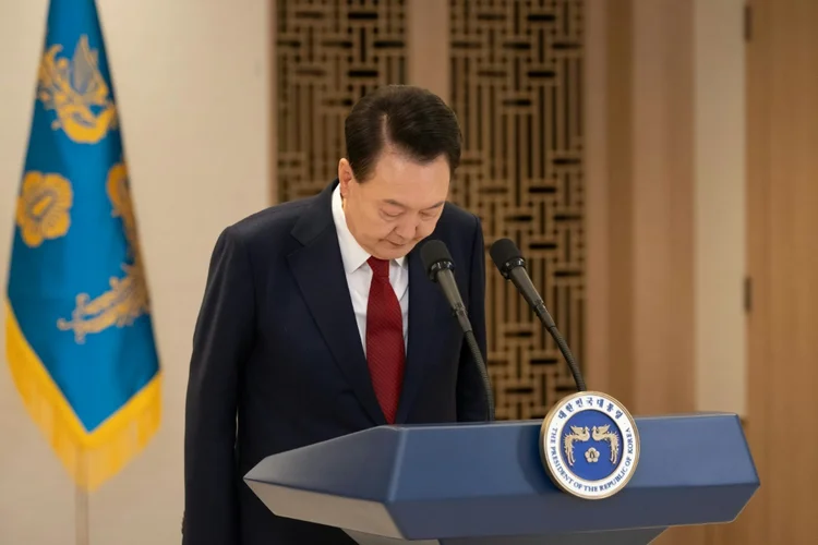 O presidente sul-coreano, Yoon Suk Yeol, faz uma reverência para pedir desculpa durante u, discurso exibido na televisão em 12 de dezembro de 2024 (AFP)