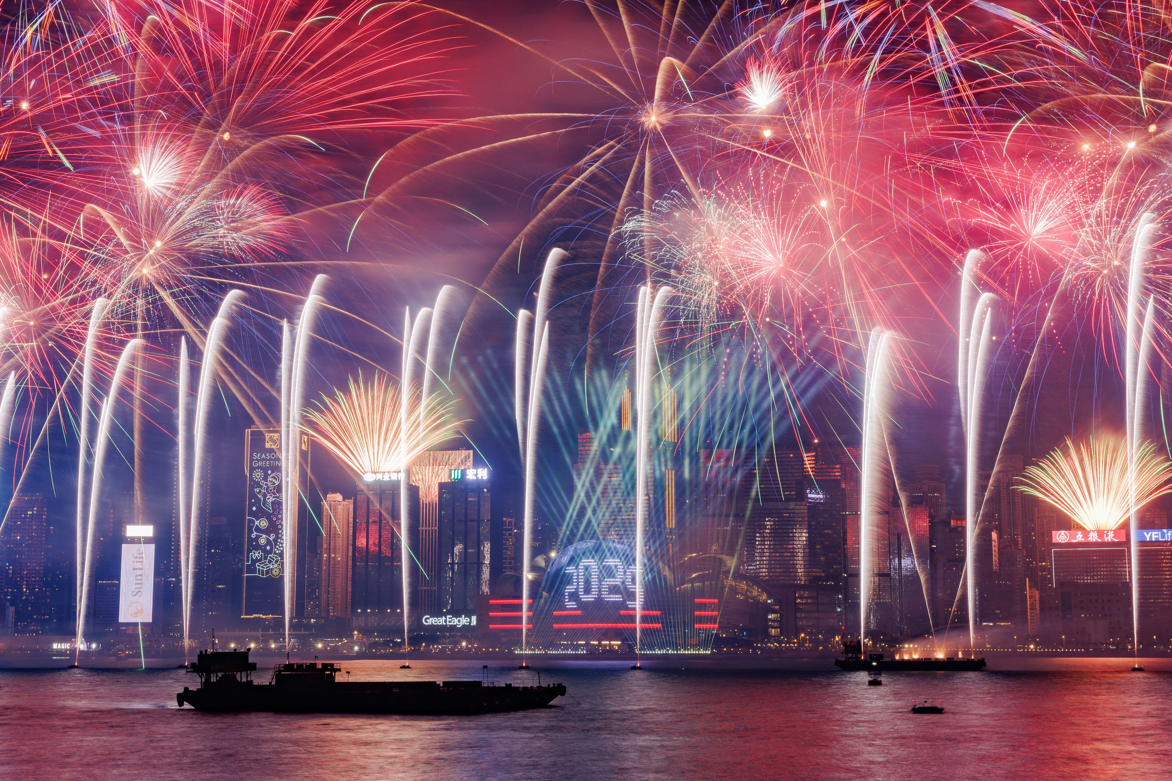 This photograph shows fireworks over the Victoria Harbour to celebrate the New Year in Hong Kong on January 1, 2025. (Photo by MAY JAMES / AFP)