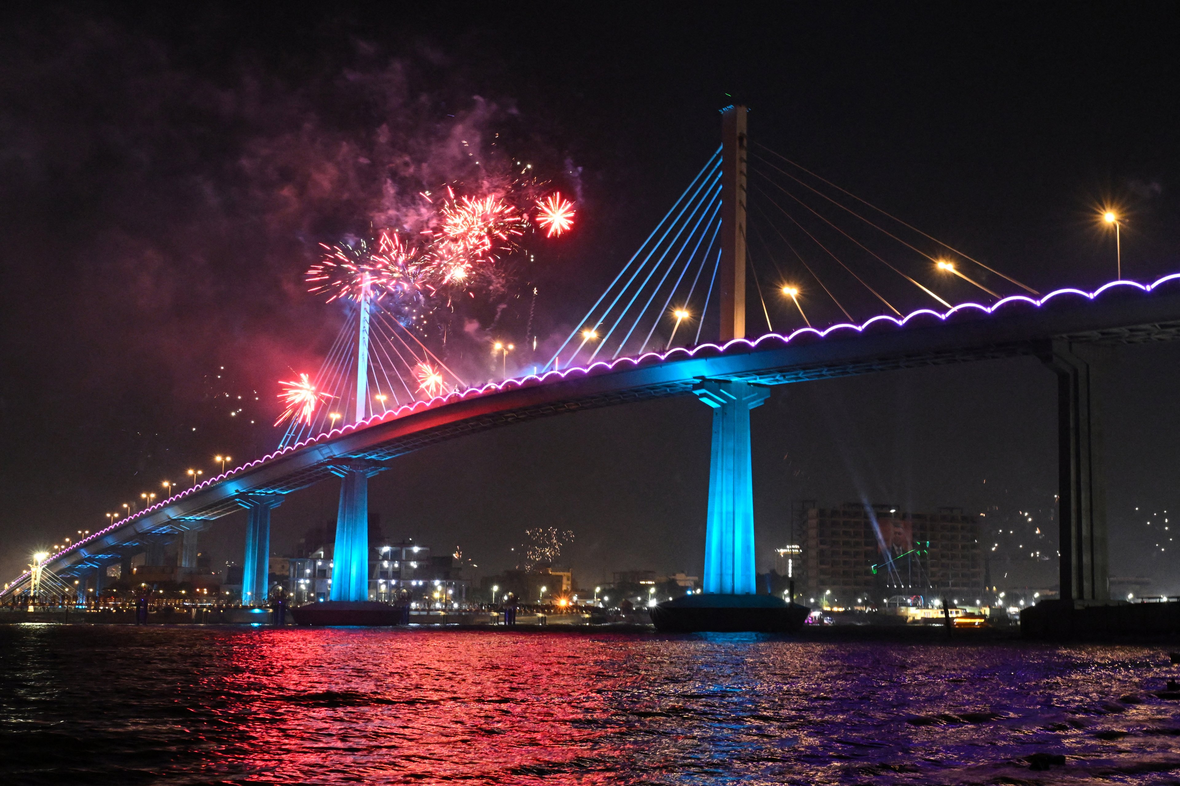 Fireworks explode over the Mohammad Baqir al-Sadr bridge during New Year's Eve celebrations in Iraq's southern city of Basra on December 31, 2024. (Photo by  / AFP)