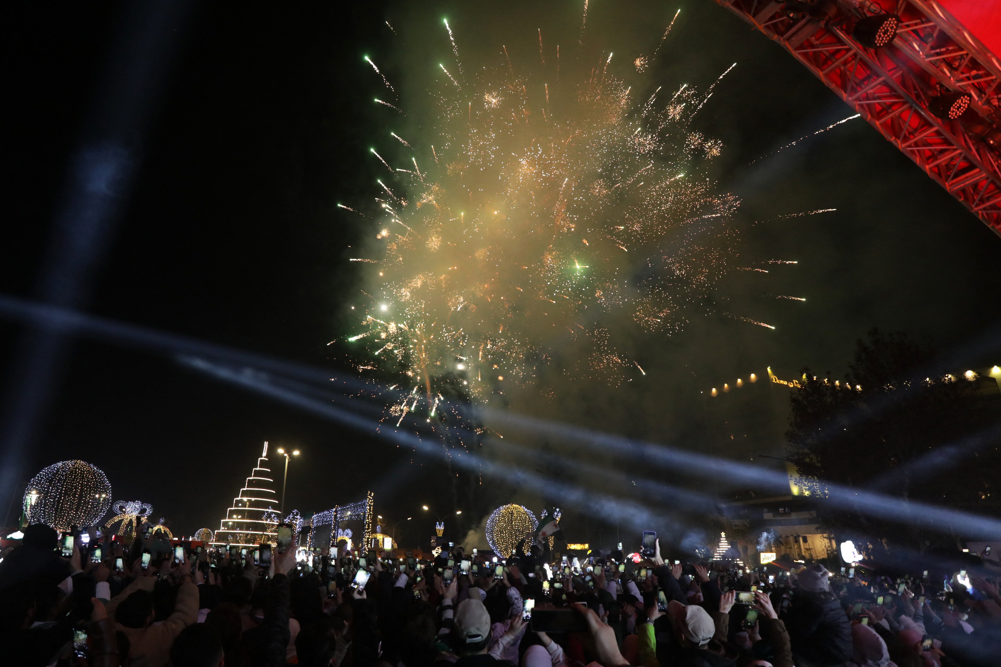 Syrians watch fireworks as they gather for New Year's Eve celebrations in Damascus on December 31, 2024. (Photo by Bakr ALKASEM / AFP)