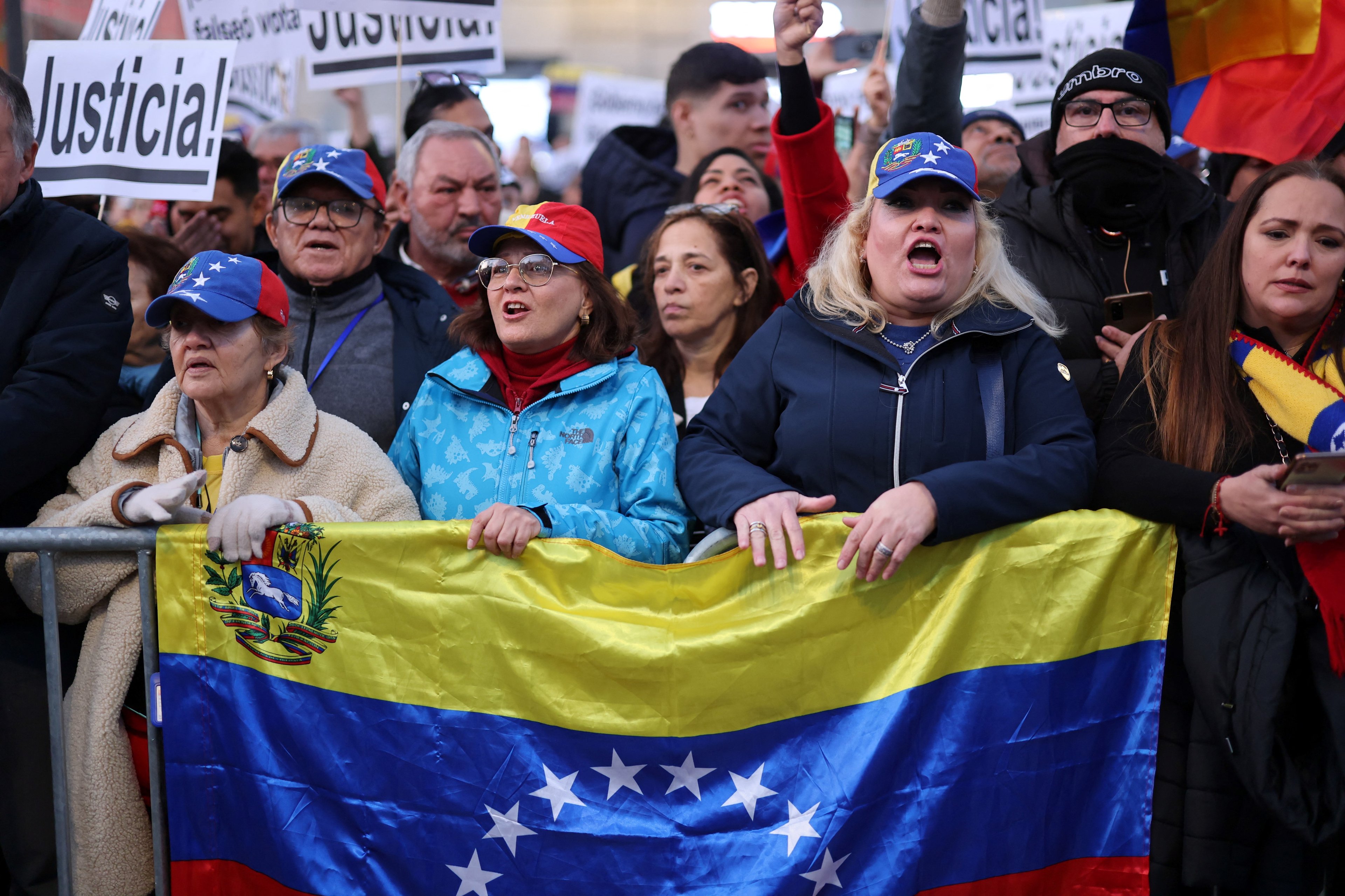 Protesters hold Venezuela's flag in Madrid on January 9, 2025 during a demonstration for democracy in Venezuela, and in support of Venezuela's opposition candidate Edmundo Gonzalez, on the eve of the Venezuela's presidential inauguration. (Photo by Thomas COEX / AFP)